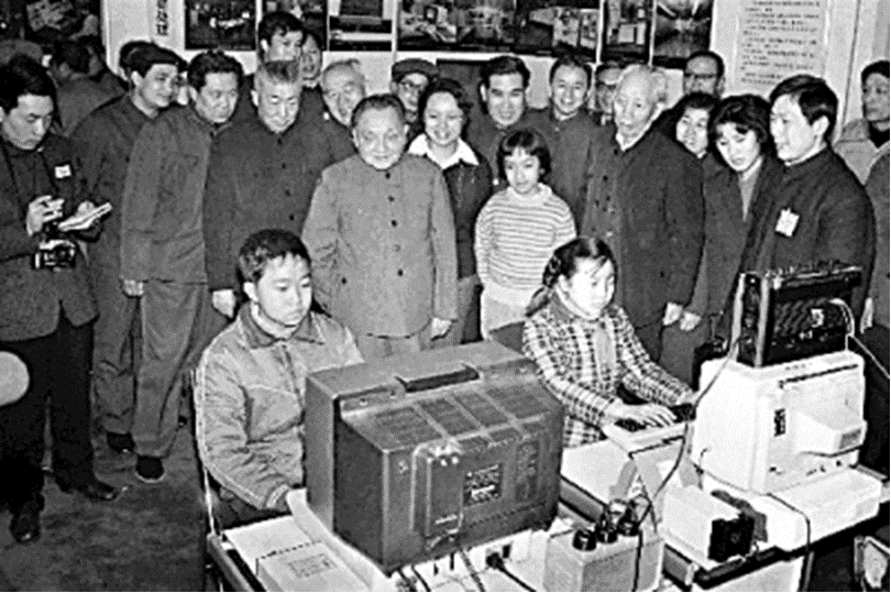 图为1984年2月,小平同志在上海观看小学生操作计算机