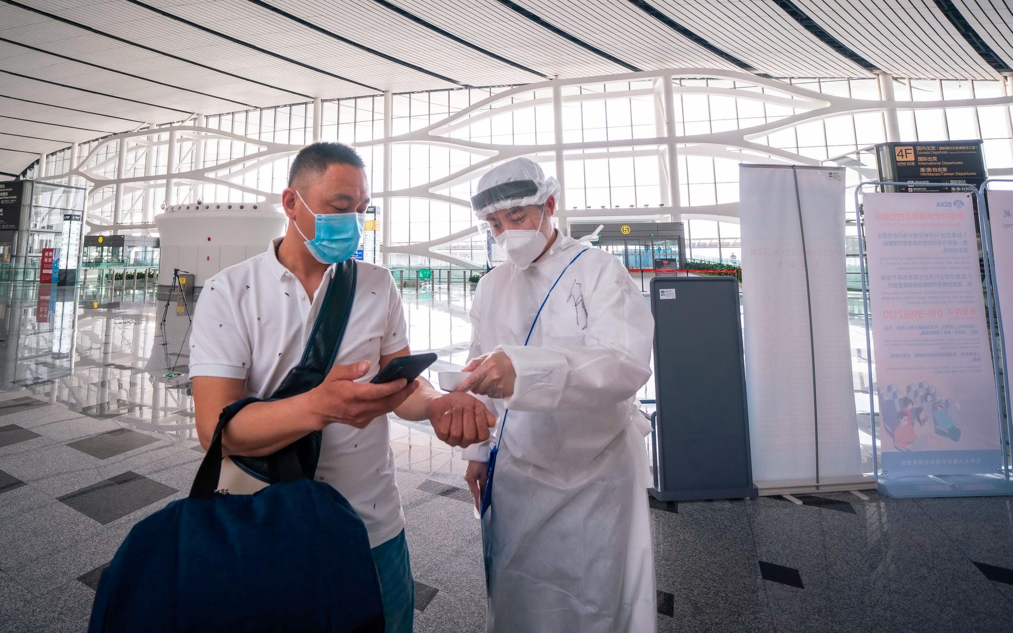 假期出行，疫情防控依然非常重要，航空公司地面服务人员将对旅客进行测温。东航供图