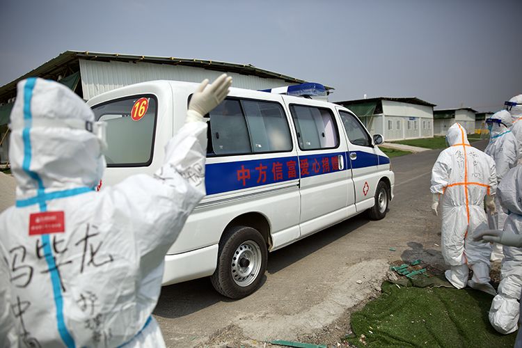  医务人员目送出院患者离开。