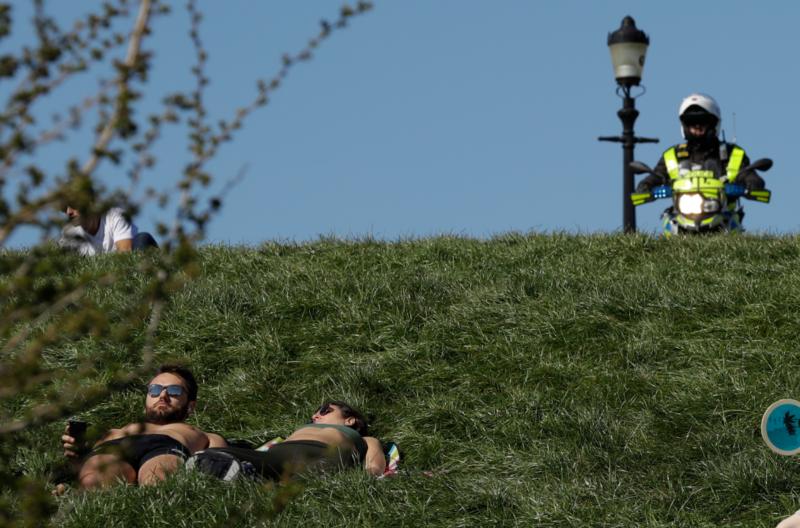 4月5日,在英国伦敦的普里姆罗斯山,警察与一名女子对话.新华社/美联