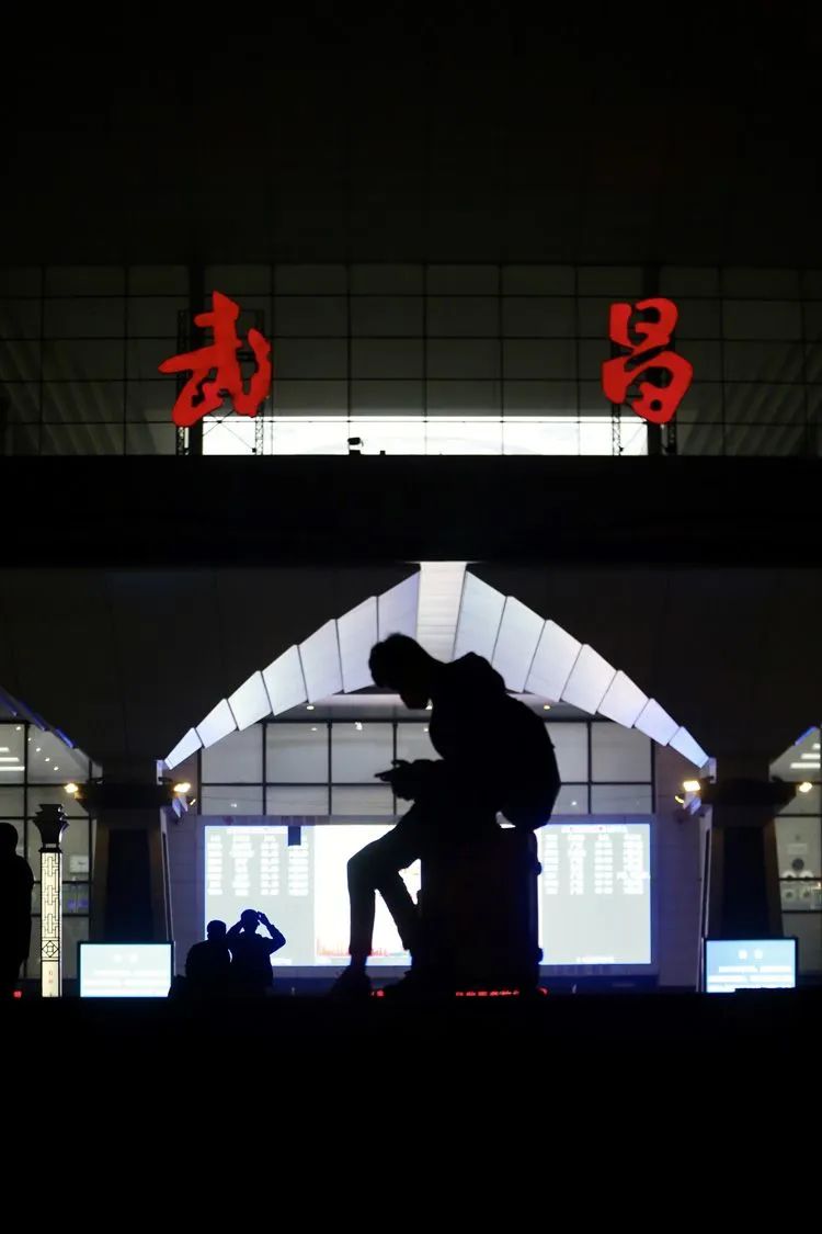 ▲4月7日晚，一位旅客在武昌火车站站前广场上等待。
