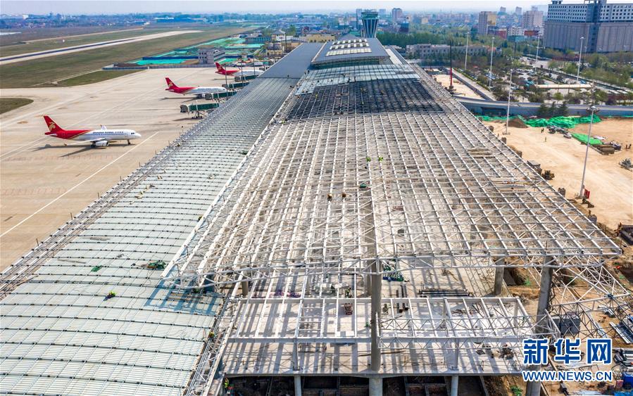 4月7日,施工人员在山西运城机场航站楼扩建工地加紧施工.