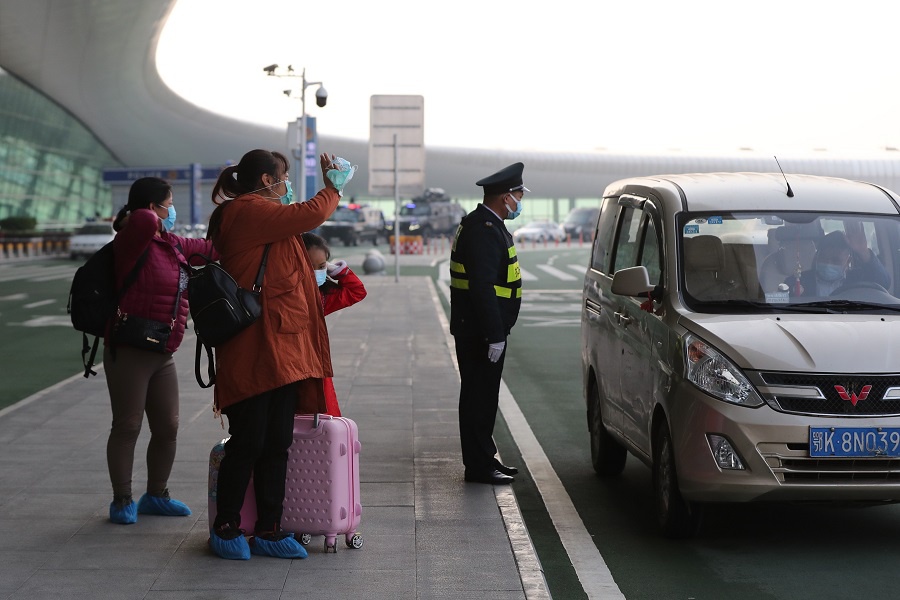 4月8日,武汉天河机场,乘客与亲人告别.(中国日报记者 王敬 摄)