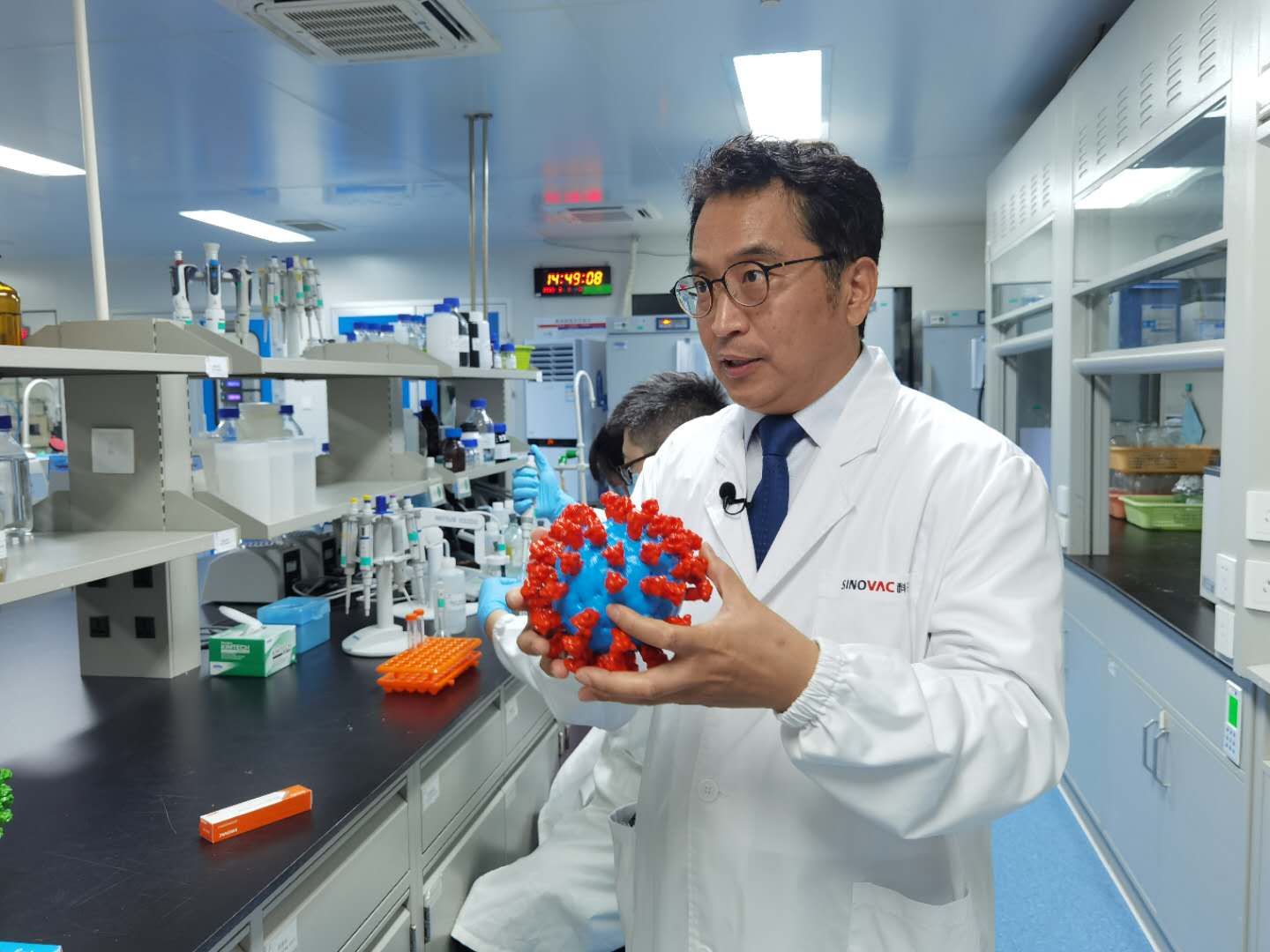 尹卫东在实验室展示新冠病毒模型并介绍新冠灭活疫苗原理。受访者供图