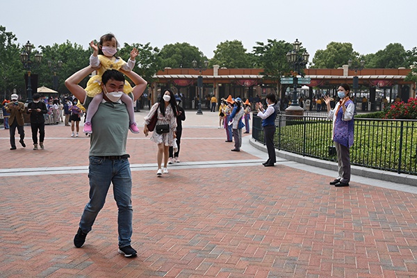 5月11日，上海迪士尼乐园，刘先生背着三岁的女儿进入乐园游玩，同行的还有他爱人胡女士。 