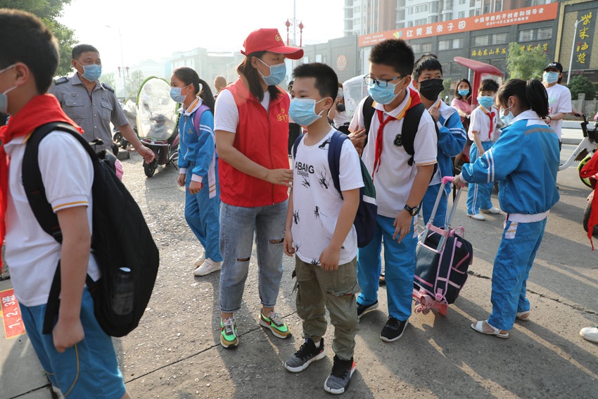 "5月11日,在抚州市东乡区北港小学门口,青年志愿者们正在帮学生排队