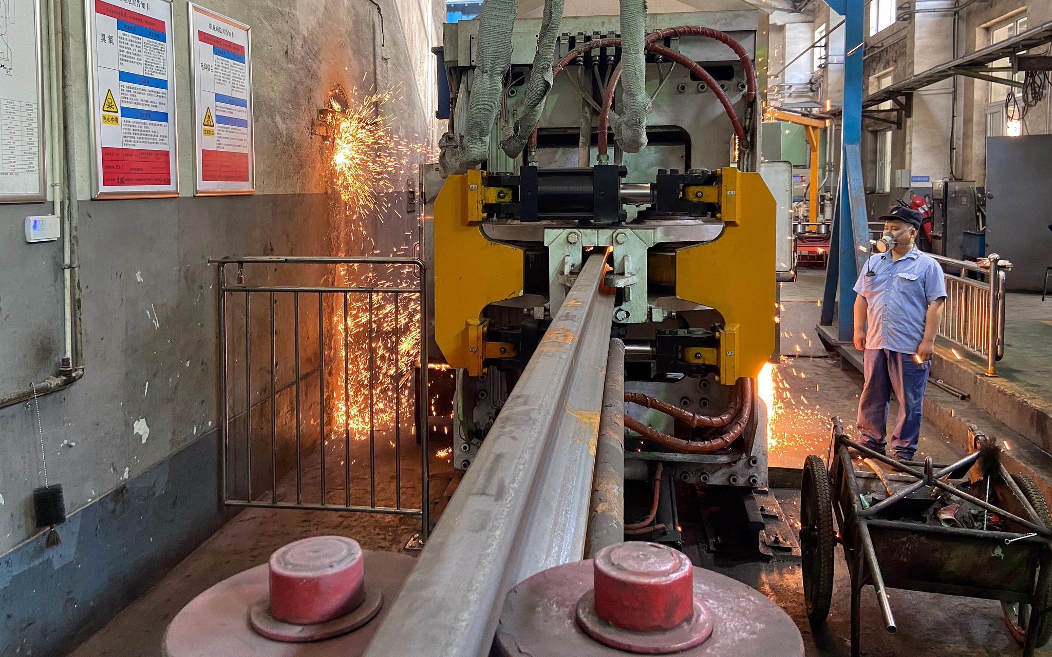  北京工电大修段焊轨基地，工人在生产线上焊接钢轨。摄影/新京报记者 王贵彬