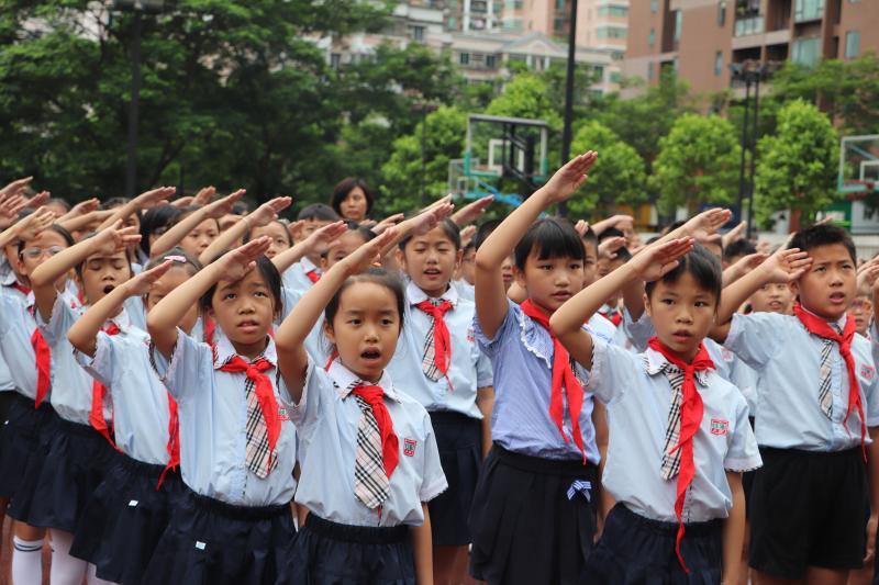 开学日,在升国旗仪式上敬礼的学生们 (资料图片)