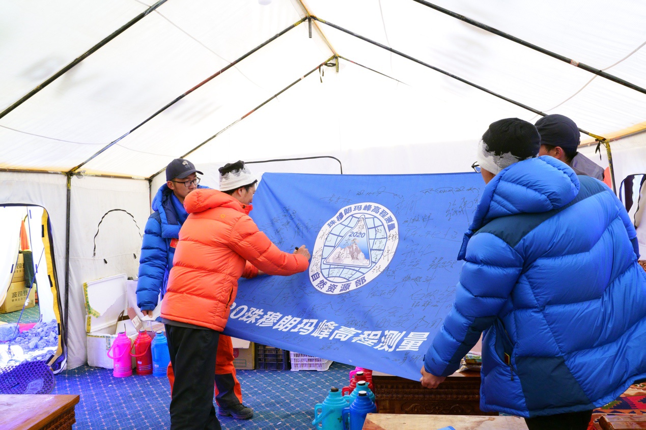  队员们在本次活动旗帜上签名留念。中国登山协会供图 卢明文摄