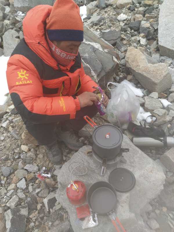 4月上旬,参与交会点普查的测绘队员在野外工作休息期间烧水煮面。受访者供图