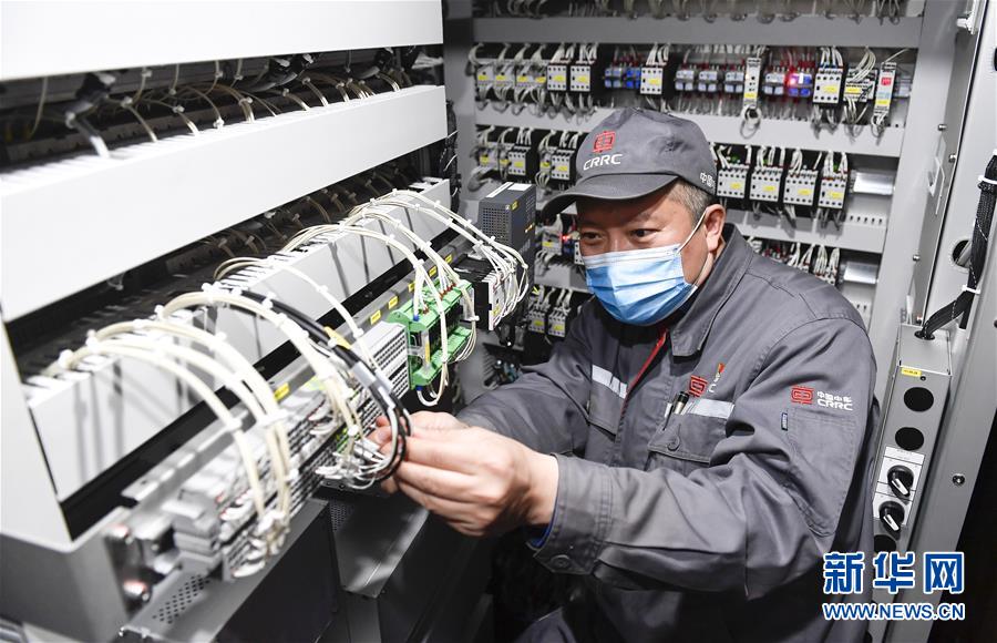 中车长春轨道客车股份有限公司首席操作师罗昭强在车间内对一列复兴号动车组列车进行调试作业（4月26日摄）。新华社记者&nbsp;许畅&nbsp;摄