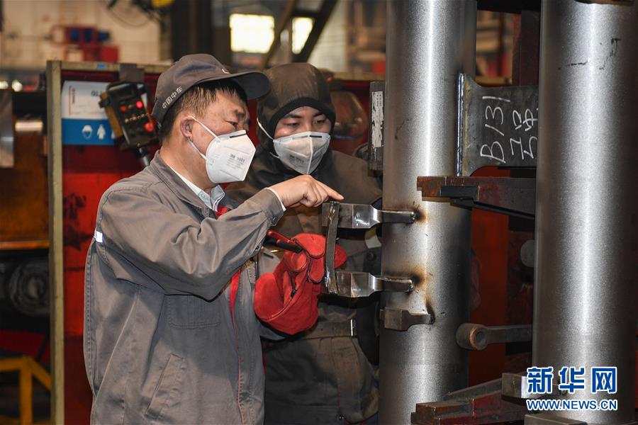 中车长春轨道客车股份有限公司高级技师李万君（左）在指导工人焊接作业中的注意事项（4月26日摄）。新华社记者许畅 摄