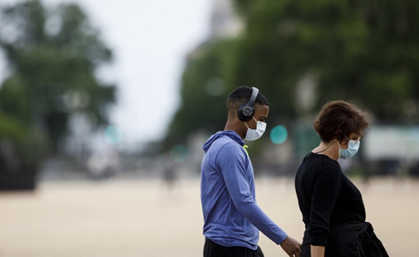 人们戴着口罩在美国首都华盛顿国家广场散步.新华社 图