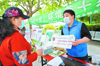 在万博苑小区，志愿者们向社区居民宣传普及垃圾分类知识。本报记者 方非摄
