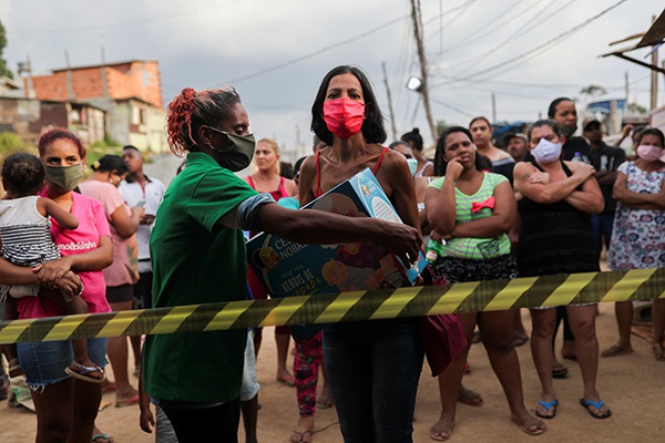 5月1日，巴西圣保罗一贫民窟居民领取食物。新华社 图