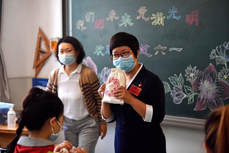 北京光明小学为学生准备了六一礼物，里面有东城区疫情防控指导手册，干湿纸巾，免洗洗手液，防疫知识小卡片，布包背面印有“我们的未来充满光明”。