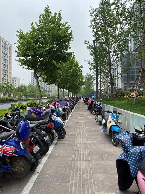 杭州市区，电动自行车停满了停车位，不得不占用一部分人行道。郭敏 图