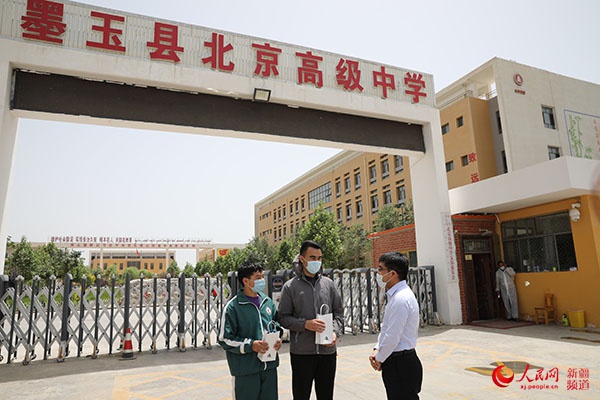 图为许泽玮来到墨玉县北京高级中学看望学生.