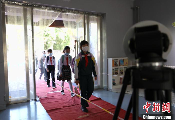 学生有序通过设置在教学楼入口处的测温区。 杨迪 摄
