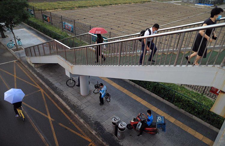 中关村东路,市民在过街天桥下躲雨。