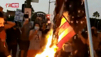 图为示威者焚烧美国国旗。图片来源：中新视频截图。