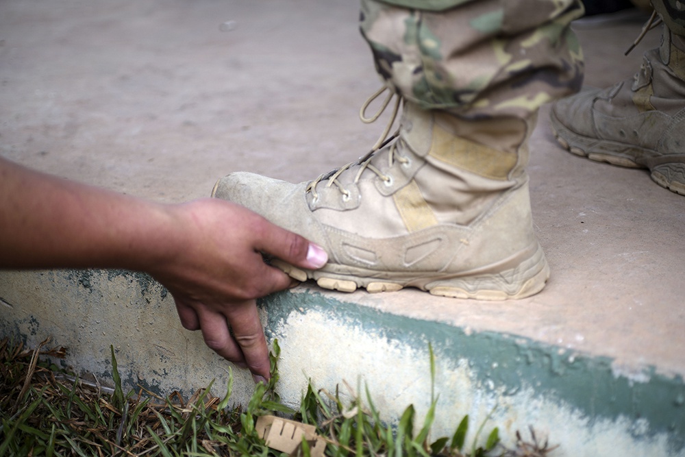 2019年3月24日,老挝万象,在枪械训练科目中不及格的学员被踩手指.
