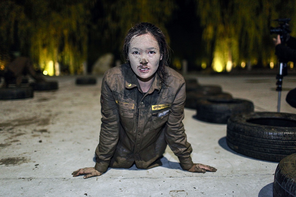 2013年11月1日,北京,一位女保镖刚刚经历过泥地匍匐.