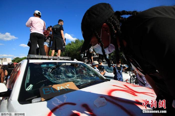 当地时间5月30日，民众在华盛顿白宫附近抗议，几名抗议者站上一辆特情局的汽车。