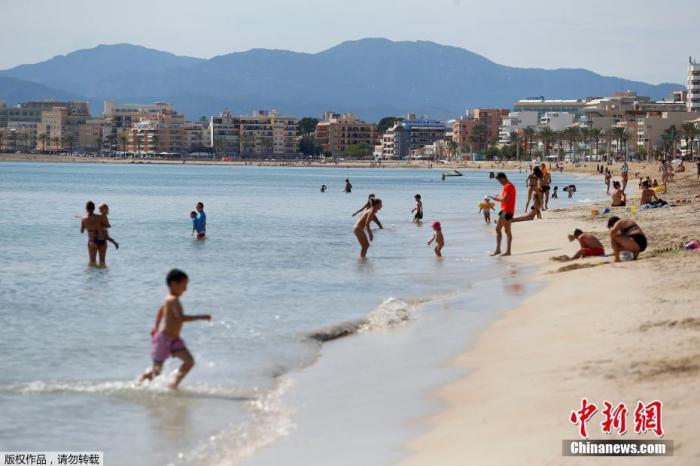 资料图：当地时间5月25日，民众在西班牙大加那利岛重新开放的海滩上玩乐休闲。
