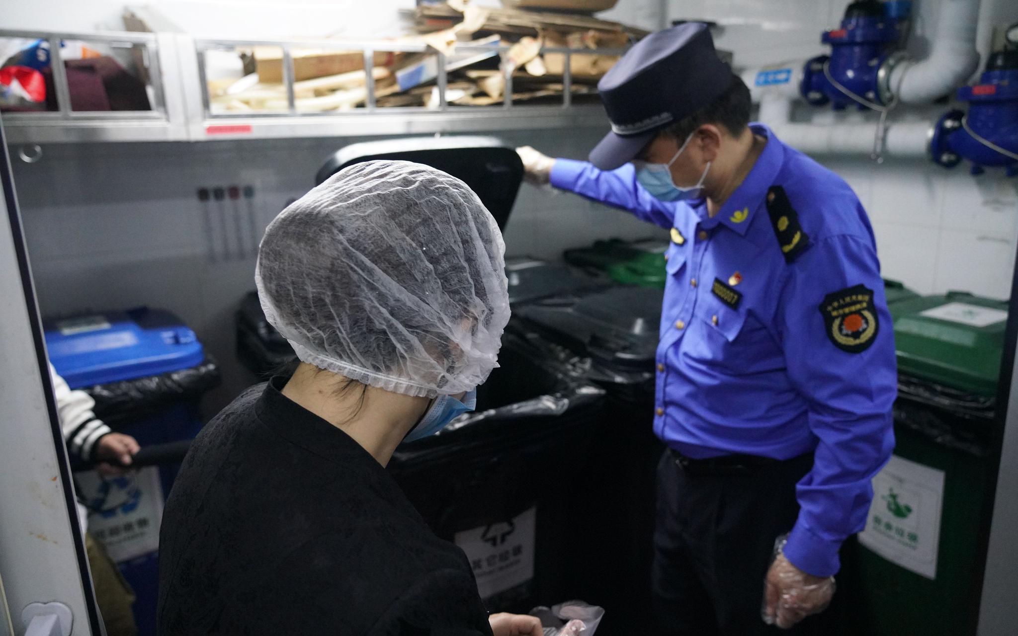 城管队员检查海底捞火锅餐厅后厨的生活垃圾分类投放情况。北京市城管执法局供图