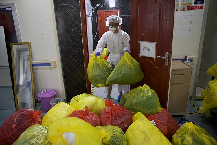  消杀人员将病区内的垃圾统一打包堆放。
