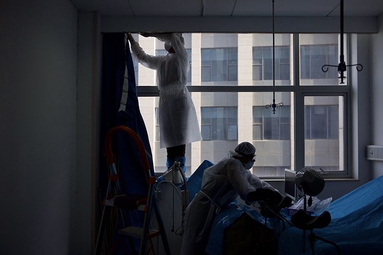  消杀人员正在拆卸病房内的窗帘。