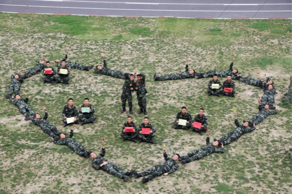 图说:官兵们在操场上摆出心形队形."爱,就要做真正的行动派!