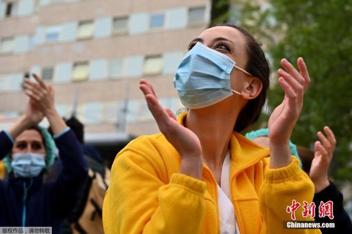 当地时间4月27日,在西班牙马德里的一家医院外,医护人员在为全国禁闭期间居家阻隔的民多们鼓掌欢呼,为他们添油打气。