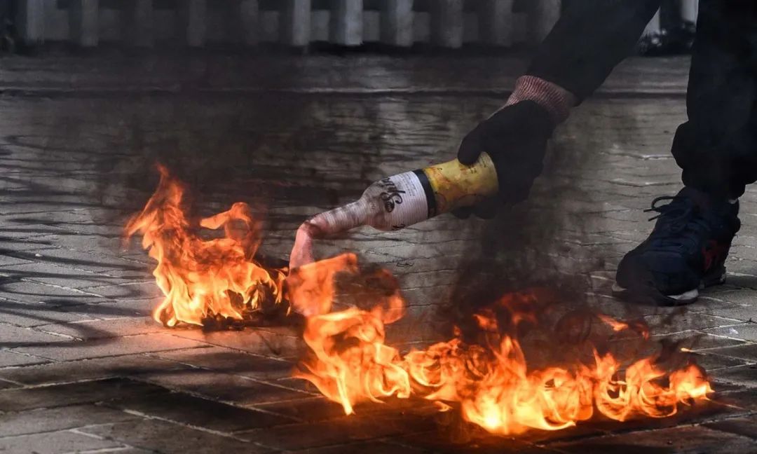 ▲去年一名抗议者放火燃烧莫洛托夫鸡尾酒，然后将其扔向驻香港政府总部外警察局。