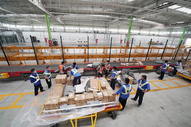  在大兴机场货运仓库，一件件打包好的货物安检完成后通过传送带运送至指定区域，在顺丰货运航班抵达大兴机场后，返程将把这些货物运回杭州。