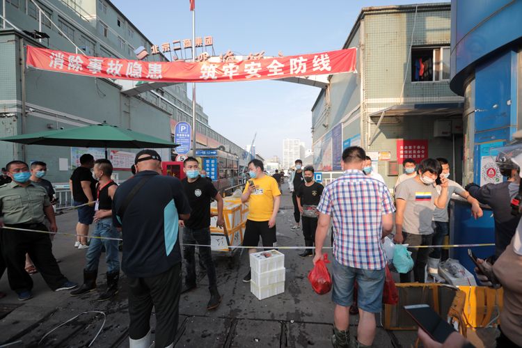 京深海鲜市场门口拉起警戒线，一位商户准备去发货。