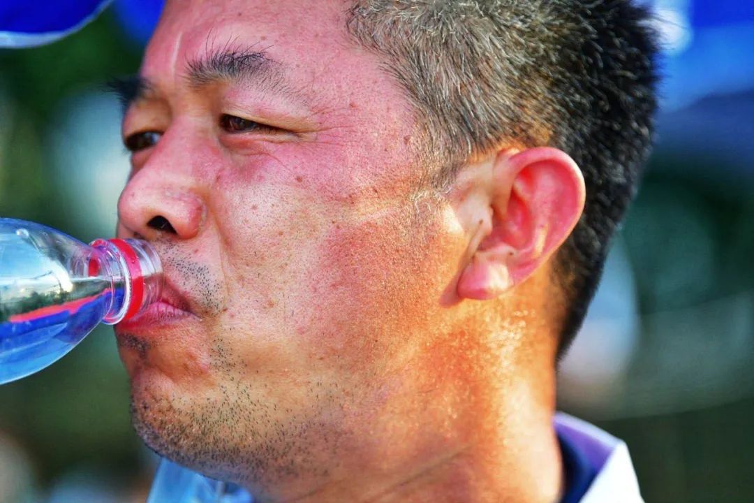 工作人员摘掉口罩后,脸上的晒痕格外明显.