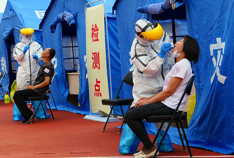 天坛体育中央核酸检测点,医护人员正在对每位登记的居民进走咽拭子采集。