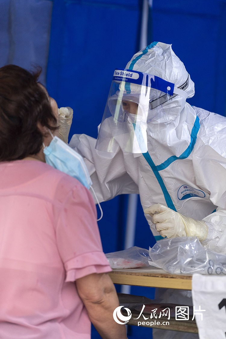 北京:医护人员为市民进行咽拭子采样