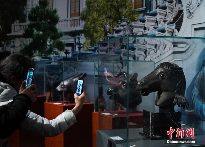 资料图：观众在马首铜像（右）前拍照。中新社记者 张兴龙 摄