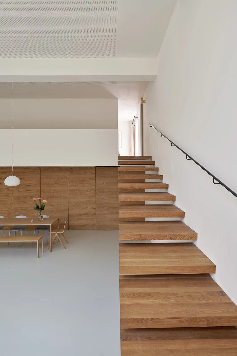 木质楼梯,木质餐桌与木饰面墙面,木质感与白色墙面,还有自流平的