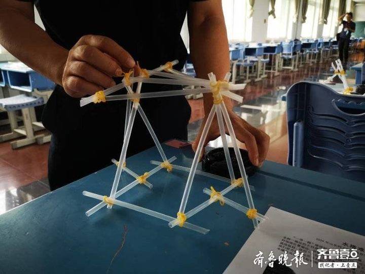 考场内,学生需利用吸管,橡皮筋和一把剪刀制作一个简易的水塔支架并 