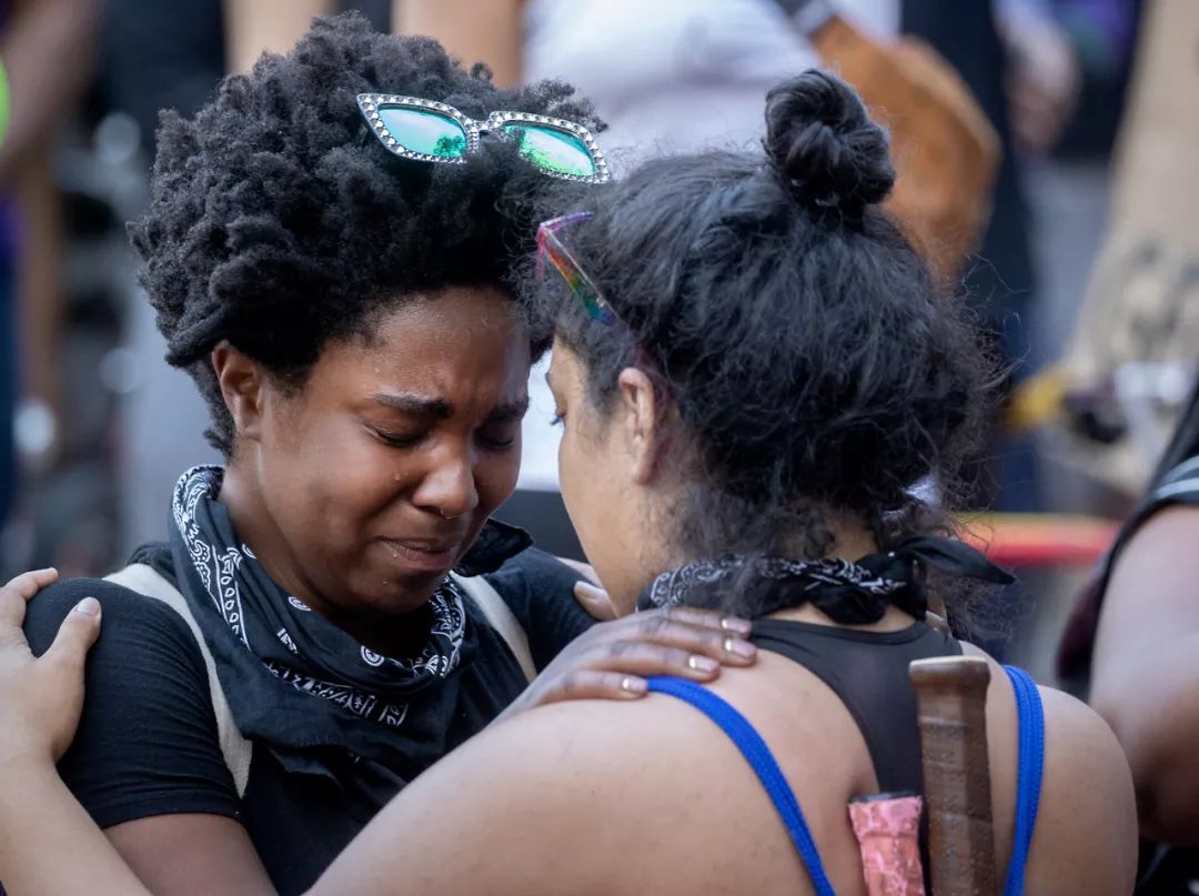  5月28日，在美国明尼阿波利斯市，抗议者集会时相互拥抱。新华社/美联