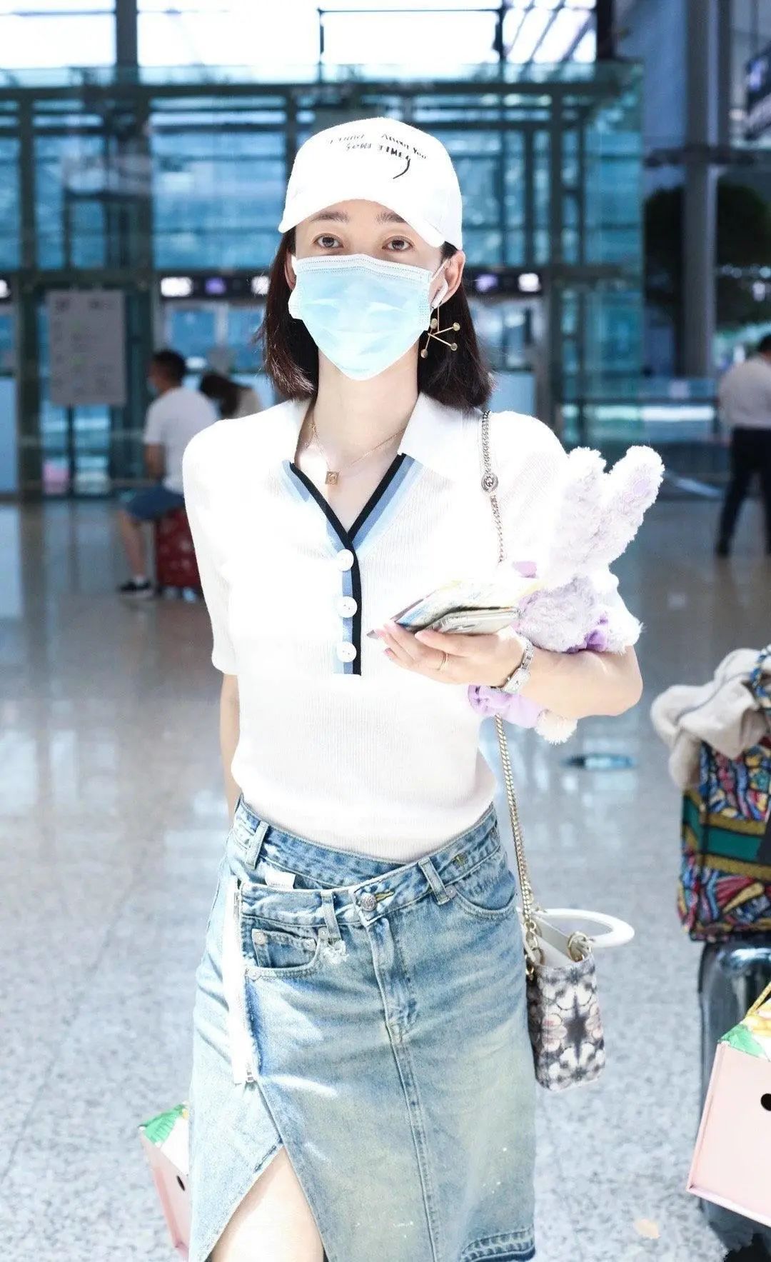 35岁王丽坤素颜走机场,白色polo衫搭配牛仔裙秀美腿,显高又显瘦