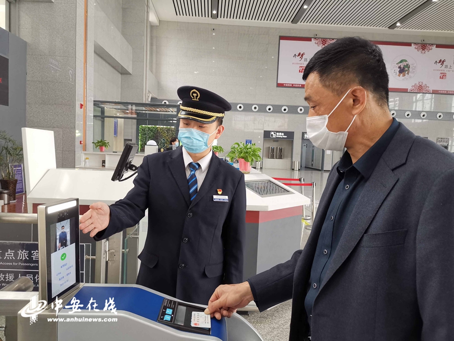 客运员引导旅客使用自助检票系统有序进站.(孙浩 摄)