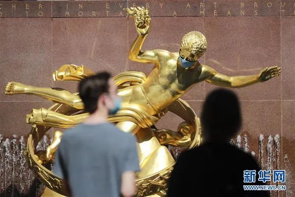  6月22日，在美国纽约洛克菲勒中心，一座雕像被“戴”上口罩。