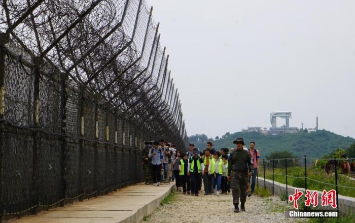 资料图：2019年，韩国向公众开放非军事区徒步游，图为游客正在体验徒步游，步道周围铁丝网环绕。中新社记者 曾鼐 摄