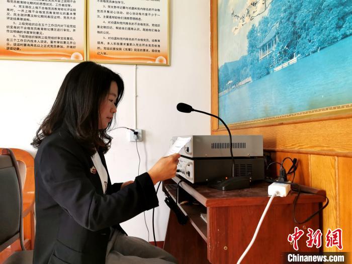 网格员官敏正在村广播室播音. 胡传林 摄