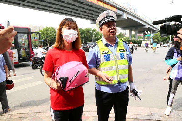 石家庄交警送头盔，宣传“一盔一带”。受访者供图